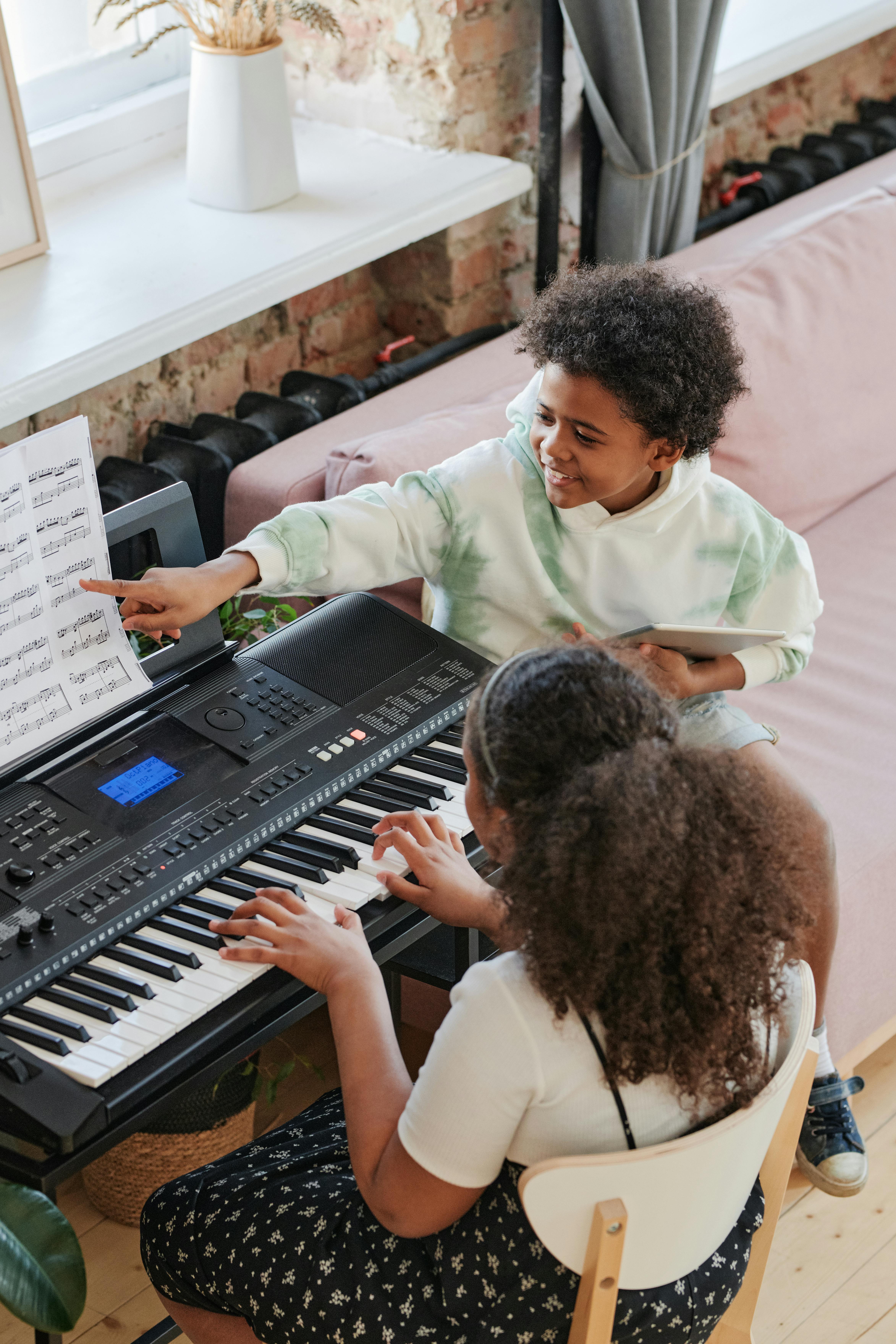 man in green dress shirt playing black electronic keyboard