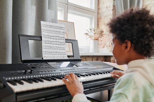 Photograph of a Boy Playing a Synthesizer