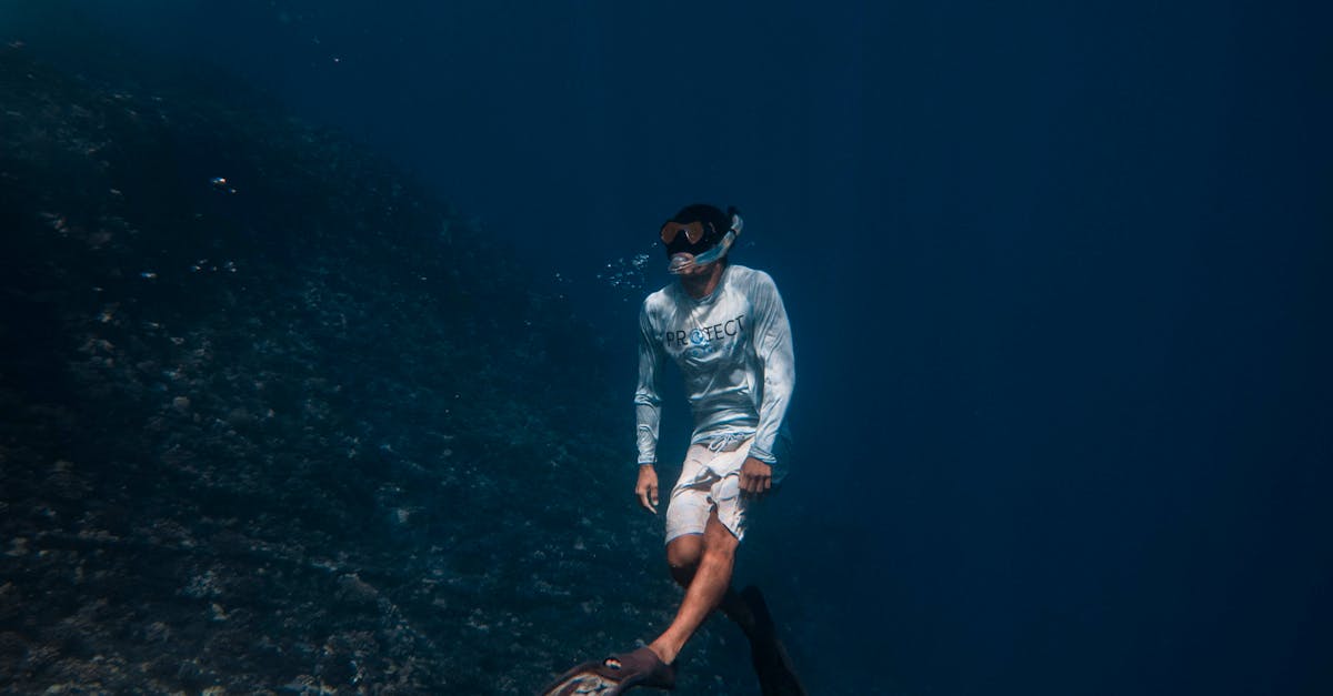 Photo by Jake Houglum A man in snorkeling gear explores the deep blue ocean near Hawaiian coral reefs.