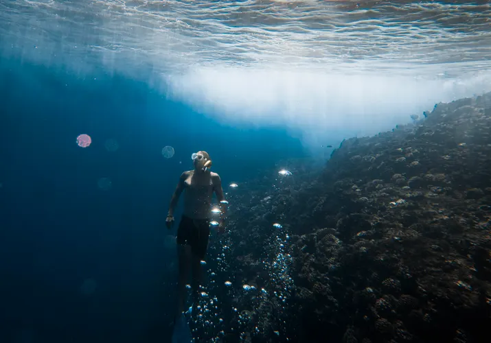 Snorkeler floating over clear turquoise water at Sharks Cove Oahu