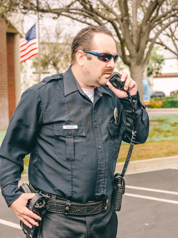 Man In Black Police Uniform Holding Black Radio