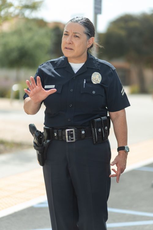 Free Experienced female police officer gesturing for attention in a city setting. Stock Photo