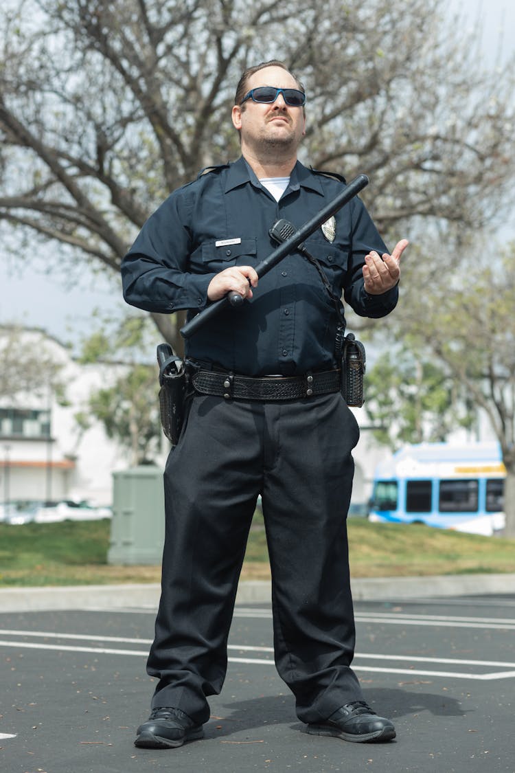 A Police Officer Holding A Baton