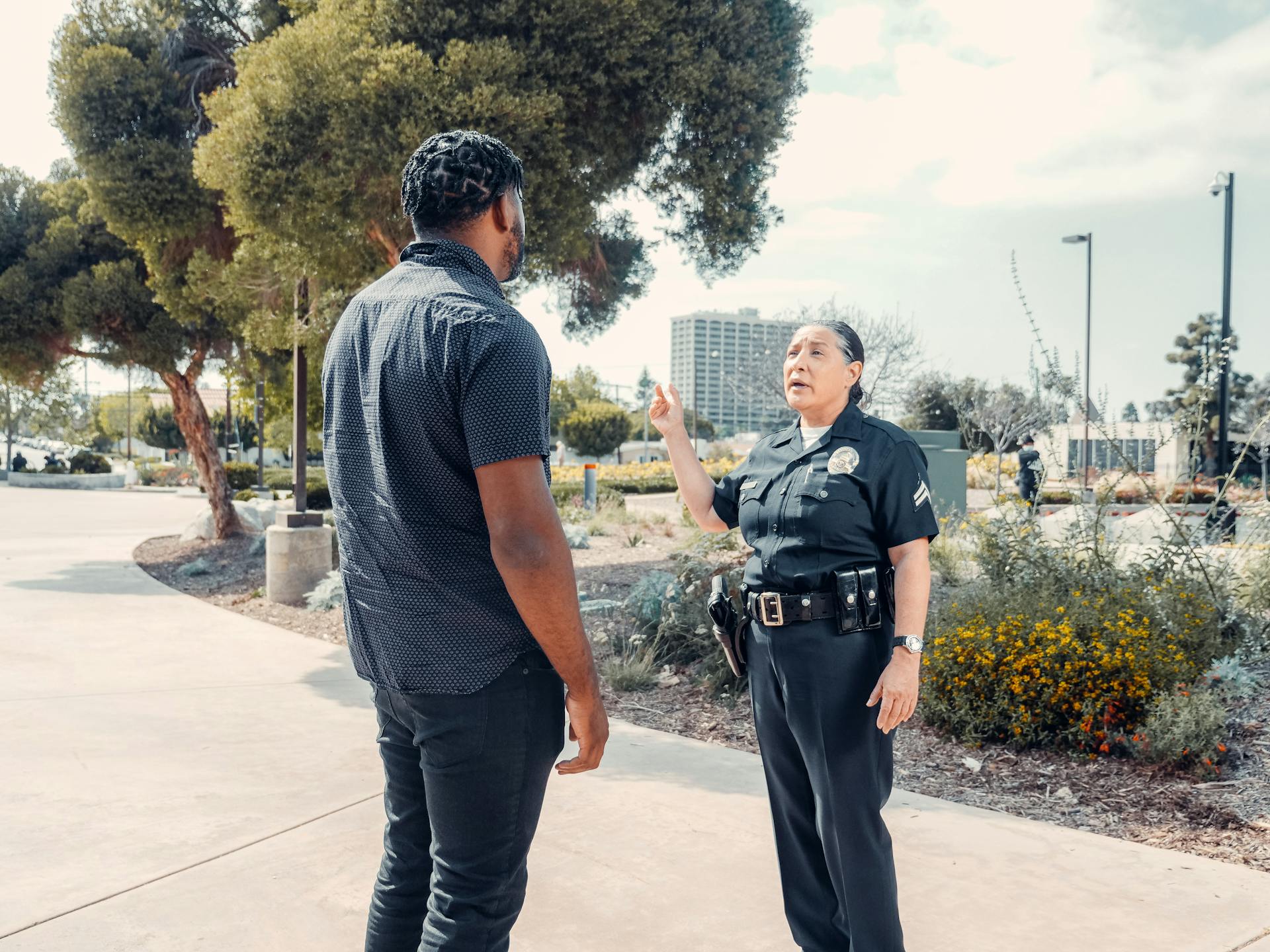 Police Officer Talking to Man in Black Shirt on the Street