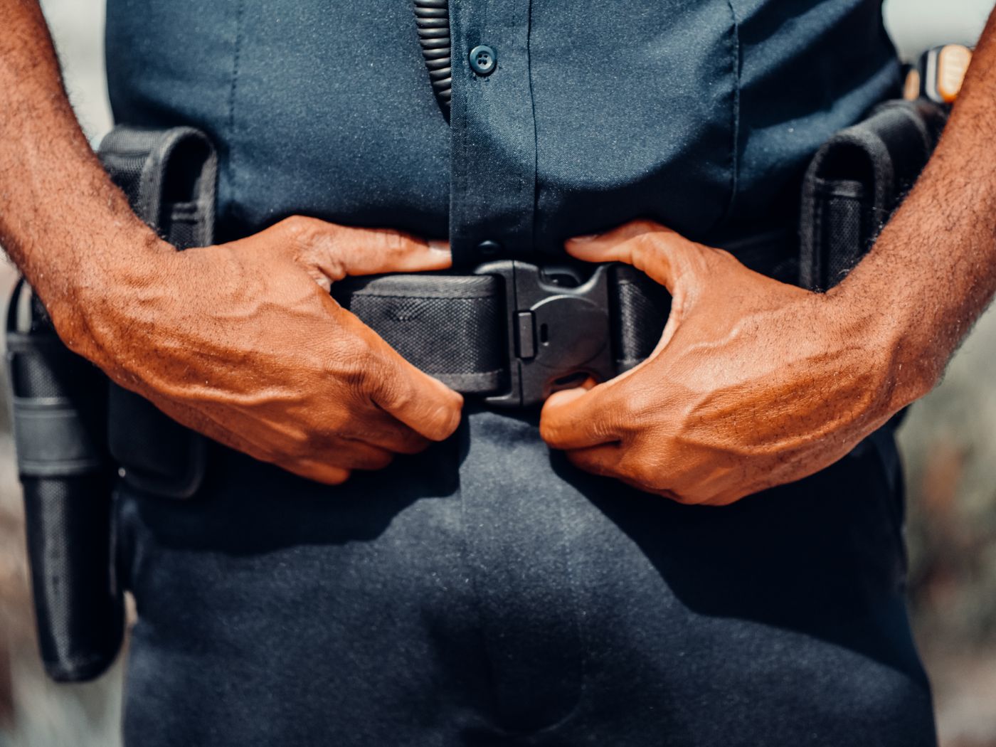 Police duty belt with holstered sidearm and equipment pouches