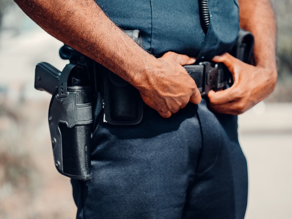 Police duty belt with holstered sidearm and equipment pouches