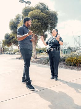 A police officer interacts with a man on a sunny day, promoting community trust and safety.