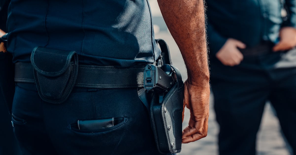 Photo by Kindel Media Close-up of a police officer's firearm securely holstered at the waist, conveying professionalism and readiness.