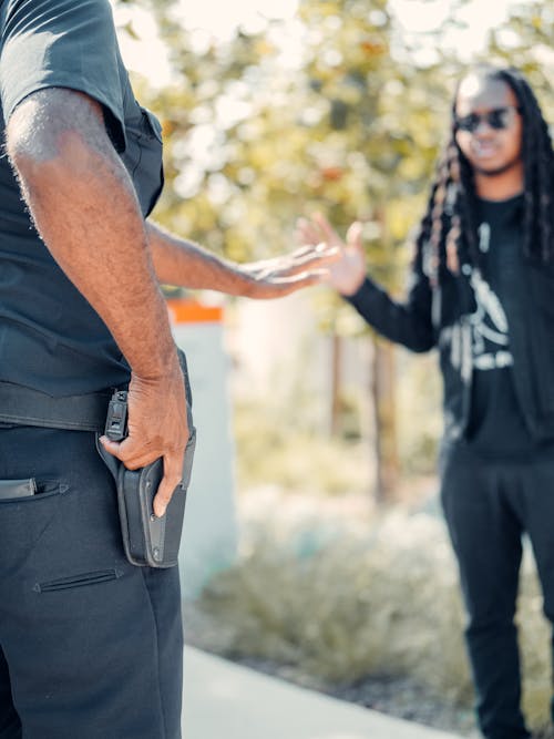 Free A Police Man Holding his Gun while Arresting a Man Stock Photo