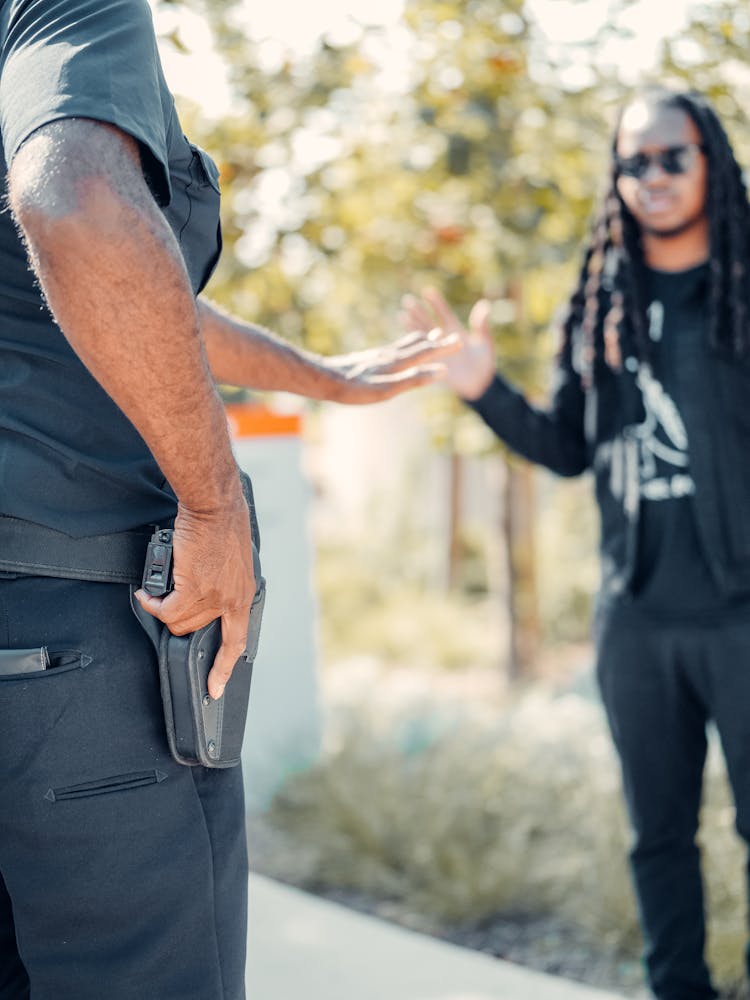 A Police Man Holding His Gun While Arresting A Man