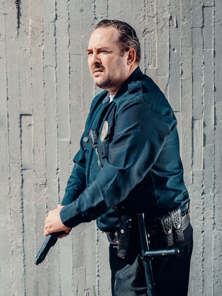 A Policeman Holding A Pistol Gun