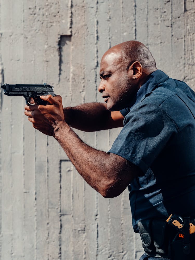 A Policeman Holding A Gun