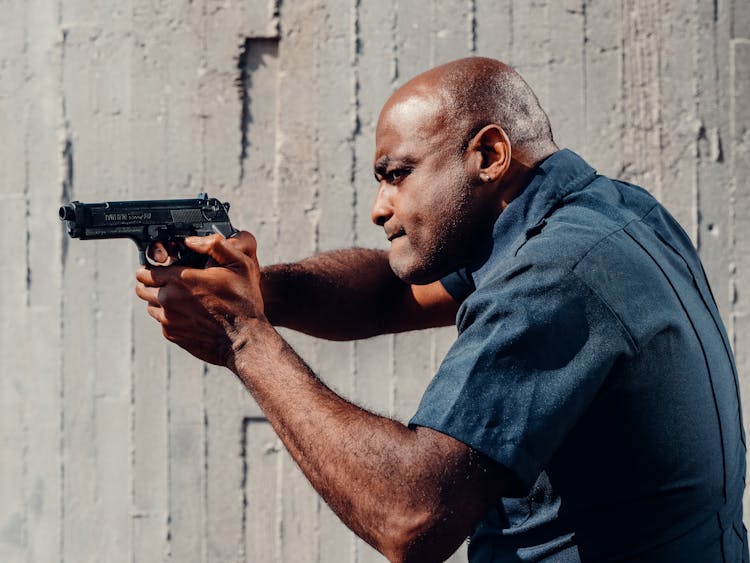 Police Officer Holding A Firearm