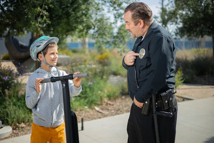 A Police Officer Pointing To His Badge