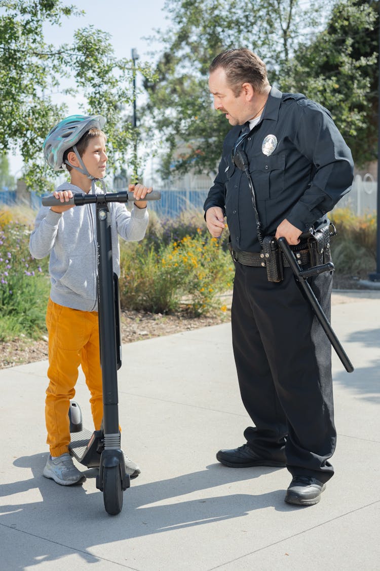 Man In Police Uniform Talking To A Young Boy