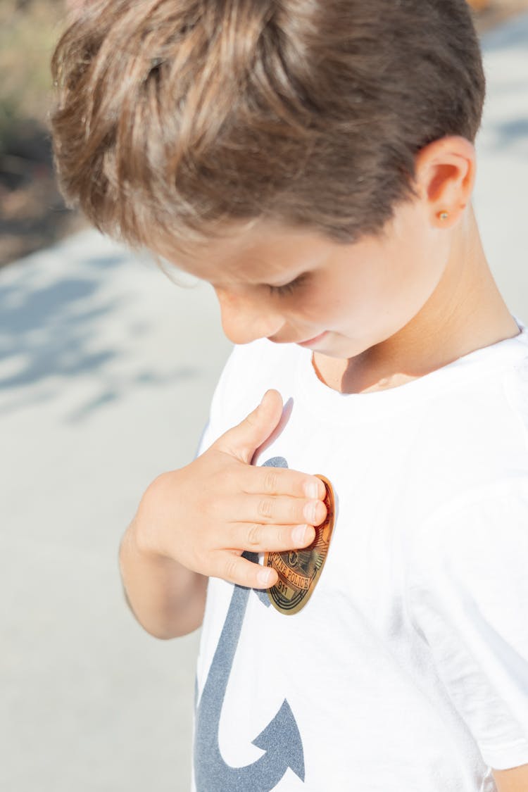 
A Boy Putting A Sticker On His Shirt