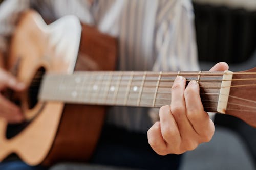 
A Close-Up Shot of a Person Playing a Guitar