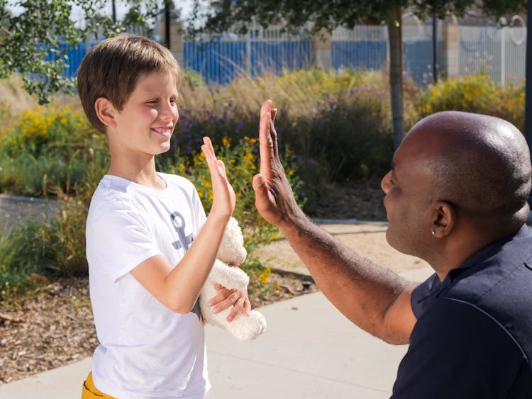 A Policeman High Fiving A Kid