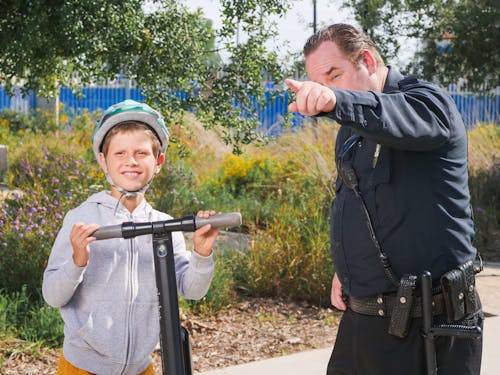 Policeman Pointing Directions to a Kid