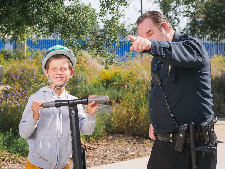 Policeman Pointing Directions To A Kid