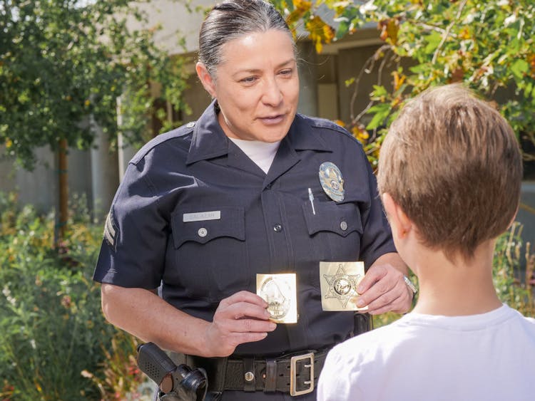 Officer Showing Police Badges To A Young Boy