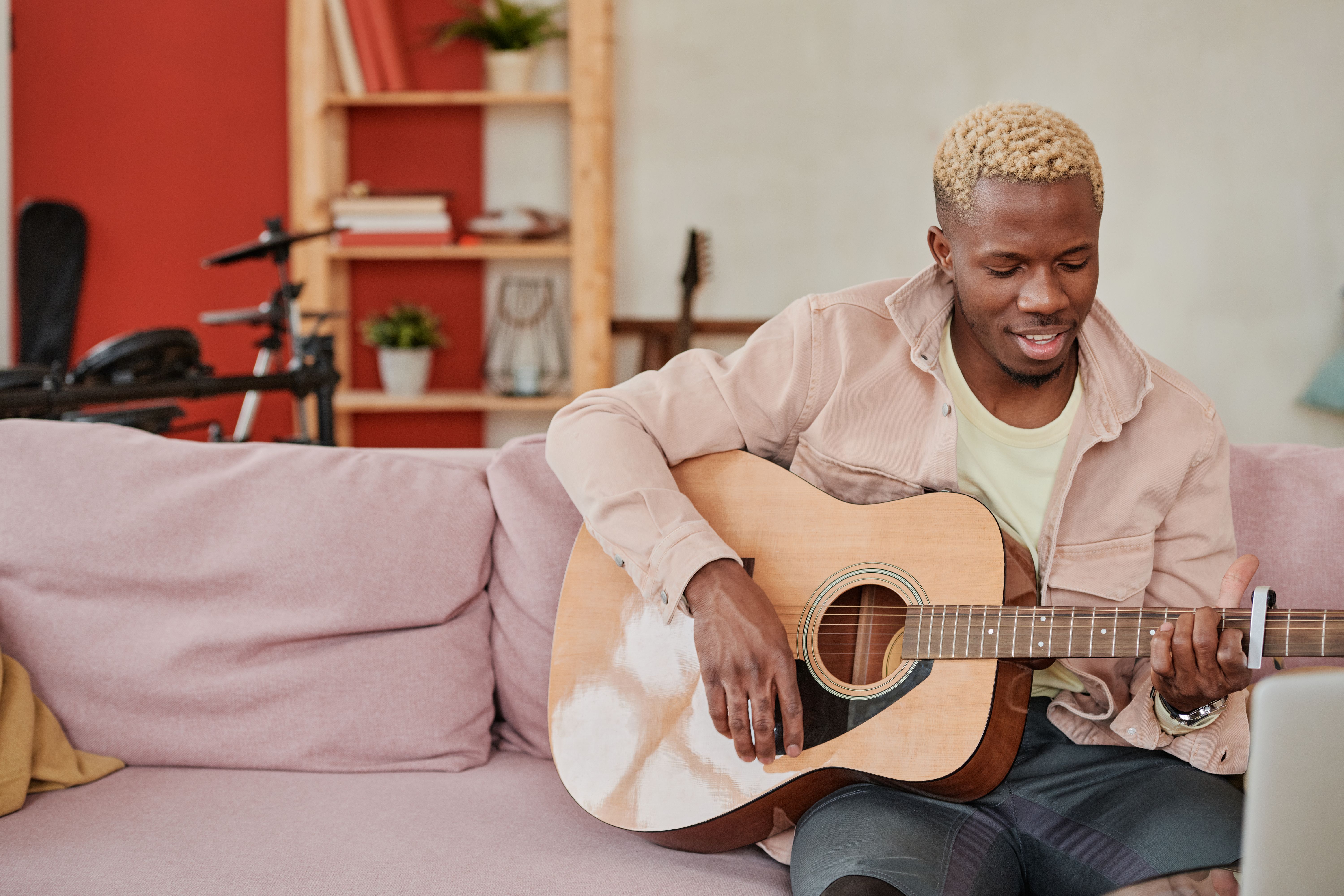 Man Sitting on Sofa While Playing Acoustic Guitar · Free Stock Photo