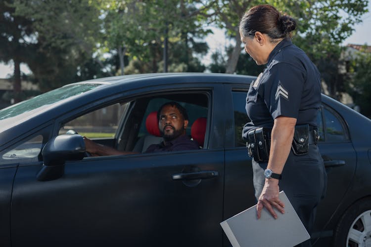 Man Driving While Looking At The Policewoman 