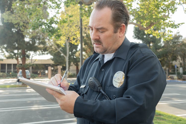 A Police Writing On A Paper