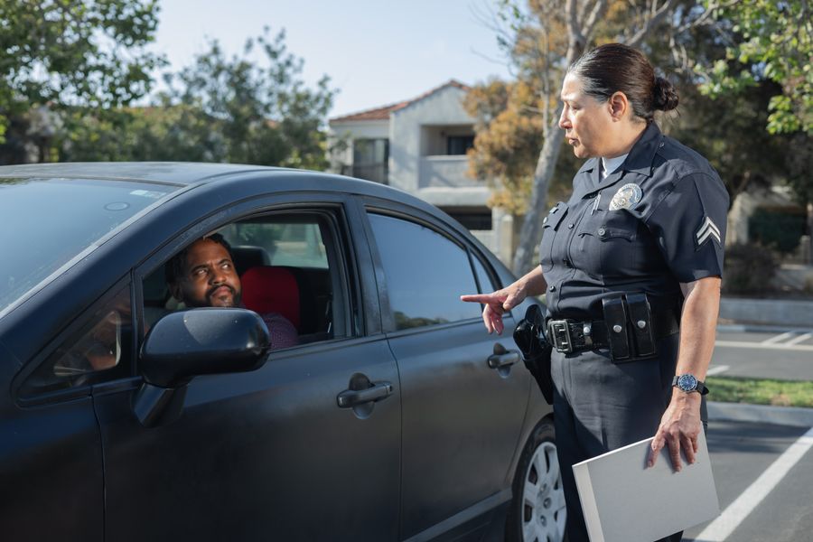 A police officer speaking with a driver during a daytime traffic stop
