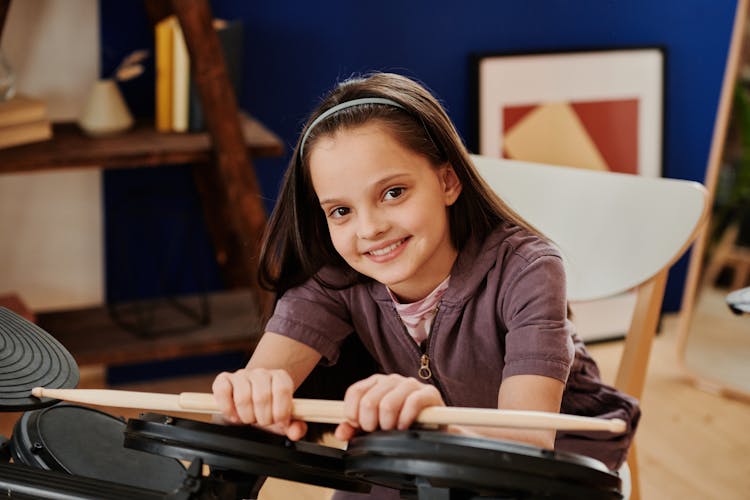 Girl Holding Drum Sticks Smiling 