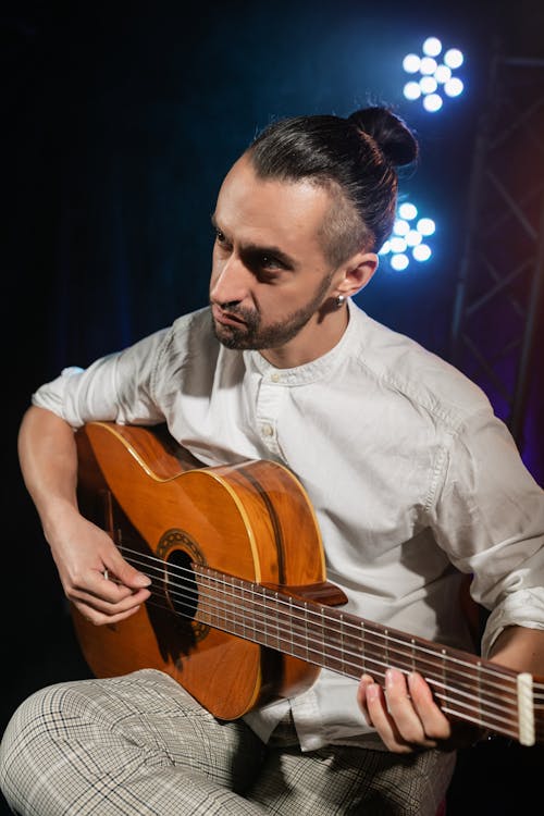 Man in Long Sleeves Playing a Stringed Instrument