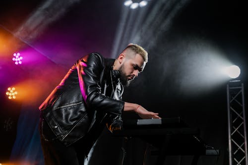 Free Man in Black Leather Jacket Playing Piano Stock Photo