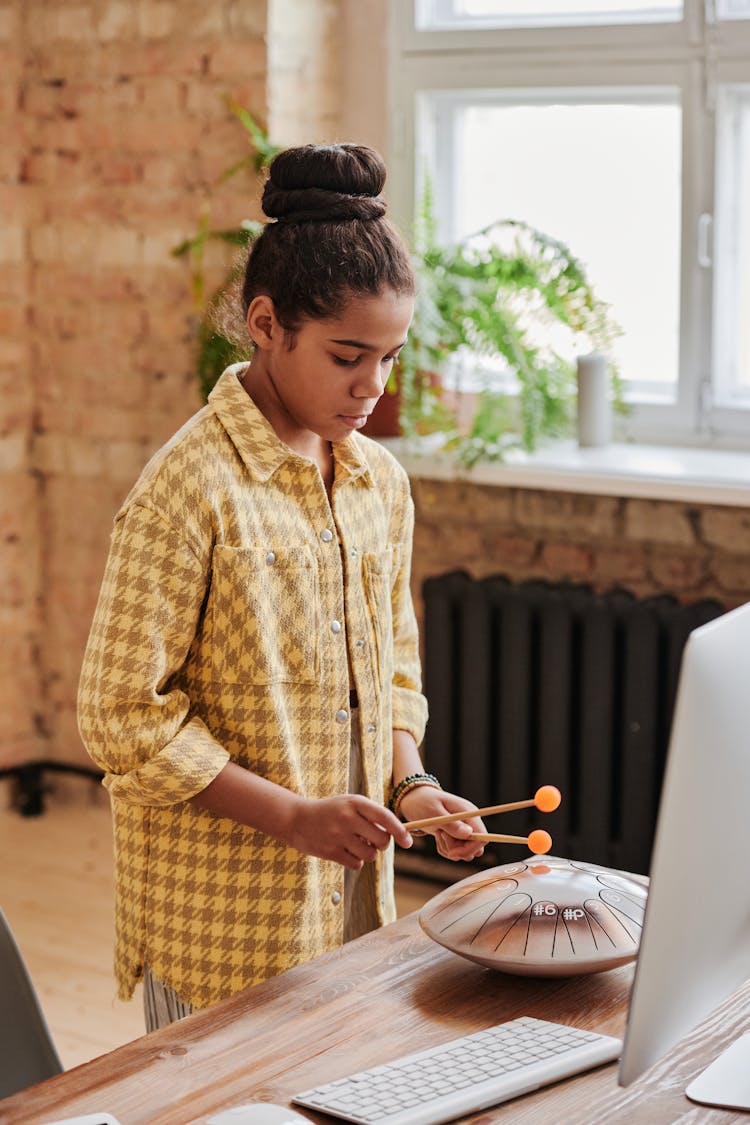 A Young Girl Playing Steel Tongue Drum