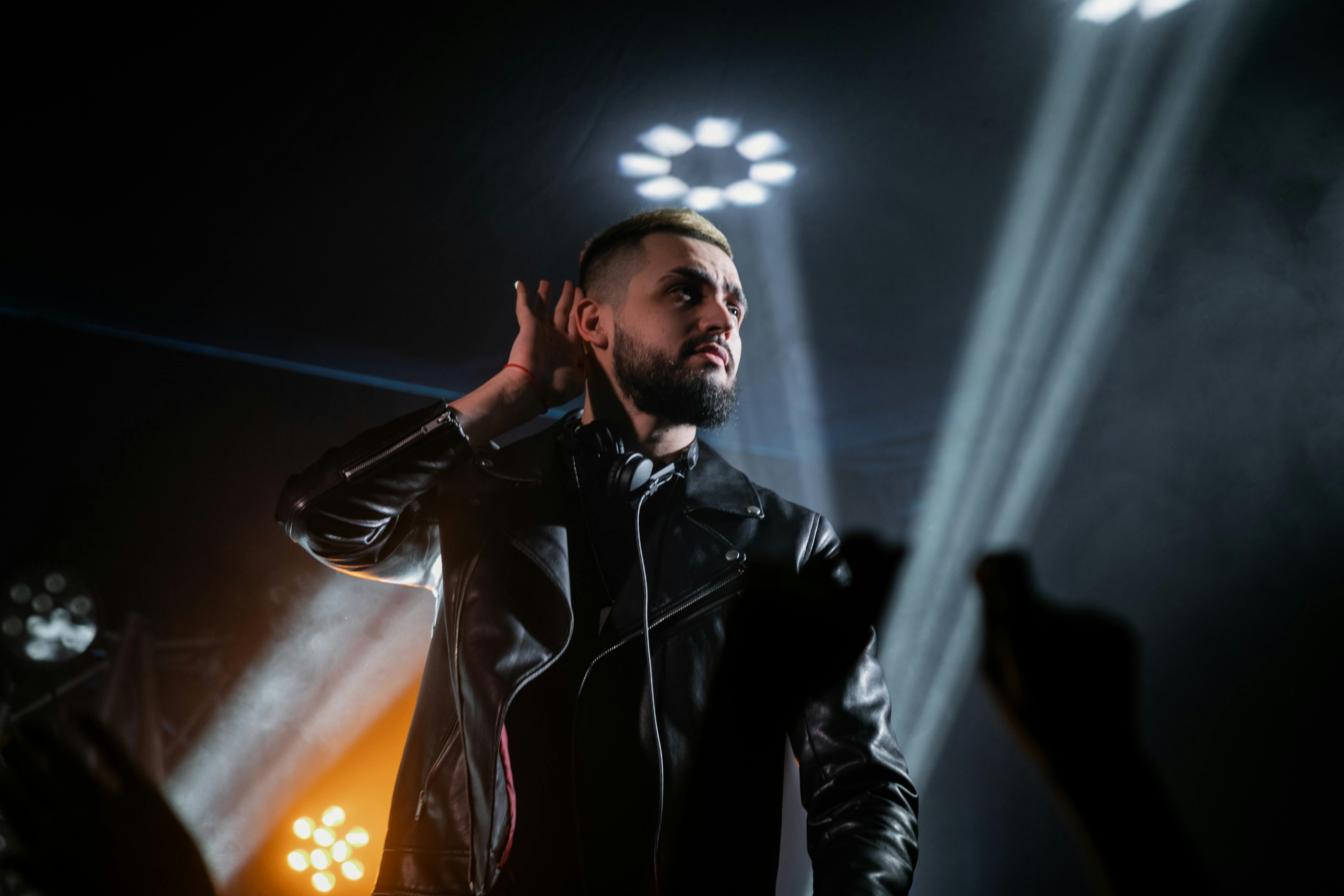 man in black leather jacket performing on stage