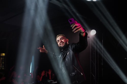 Man in Black Leather Jacket Holding Purple Microphone