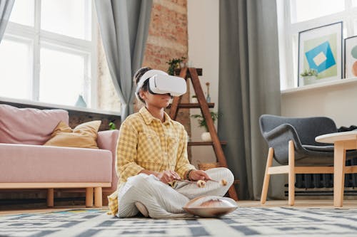A Child in Yellow and Brown Plaid Jacket Sitting on Floor Wearing VR Goggles