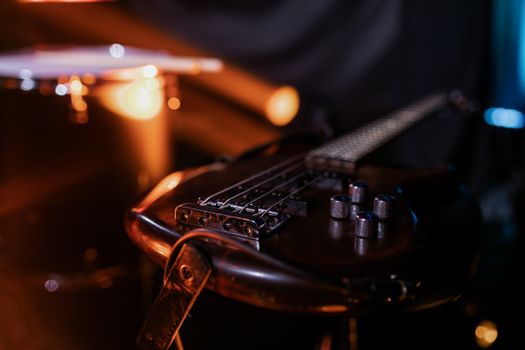 Close-up of an electric guitar on stage with moody lighting, perfect for music themes.