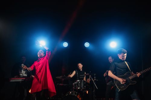 Free A dynamic musical group performing live with vibrant lighting and enthusiastic expressions. Stock Photo