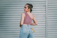 A Woman in Pink One Shoulder Top Standing Near the Roll Up Door
