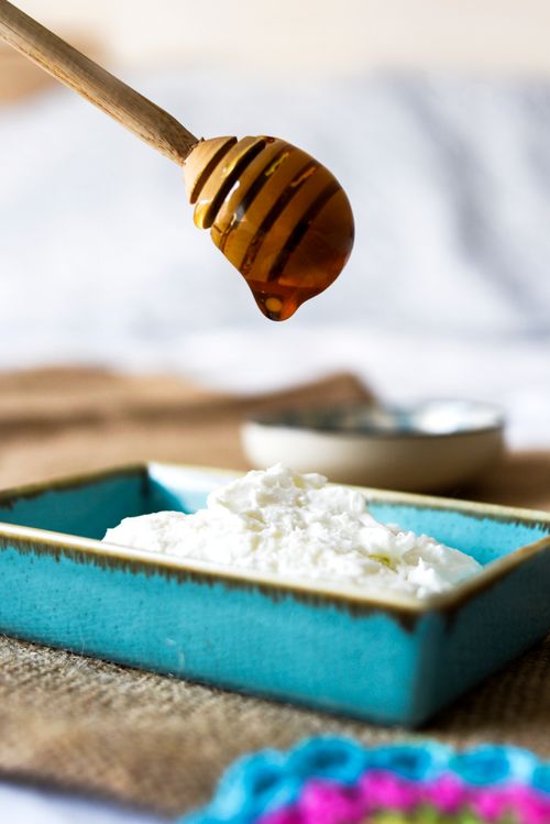 Free Close-up of honey dripping over yogurt in a blue dish, depicting a sweet and creamy delight. Stock Photo