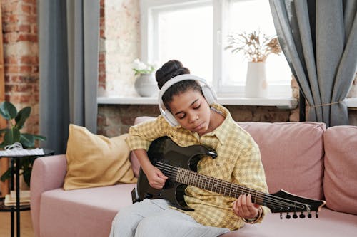 Free A Woman Playing an Electric Guitar Stock Photo
