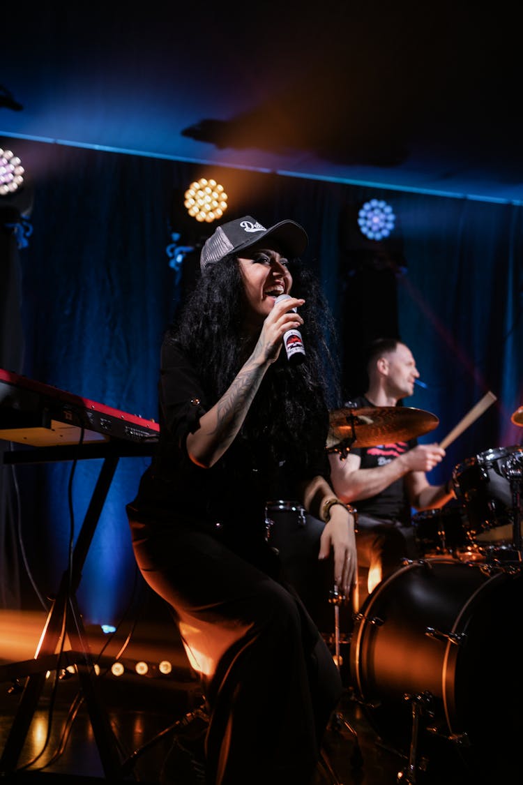 A Tattooed Woman Singing On Stage 