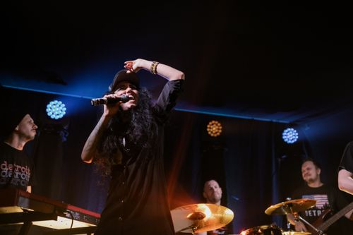 Free Dynamic live performance by a band on stage with a charismatic lead singer engaging the crowd. Stock Photo
