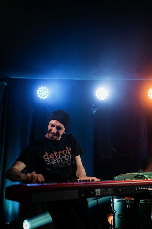 Free Musician passionately plays keyboard under colorful stage lights. Stock Photo