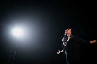Cantante femenina actuando bajo un foco dramático