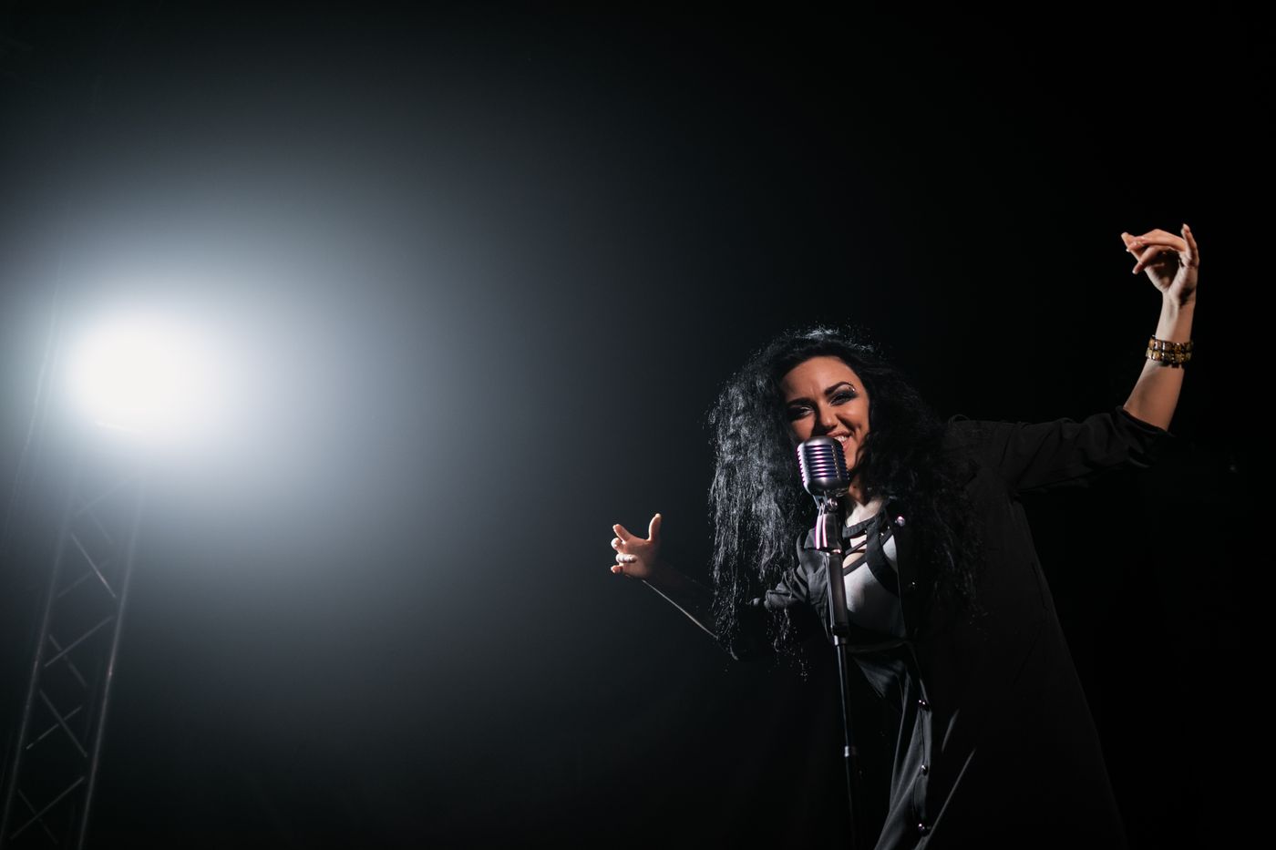 Key art for Gilded: a singer performing under a stage spotlight. Photo by Alena Darmel on Pexels