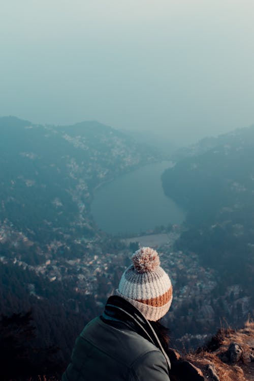 Free Person Wearing Knit Hat Looking at View of Mountains and Lake Stock Photo