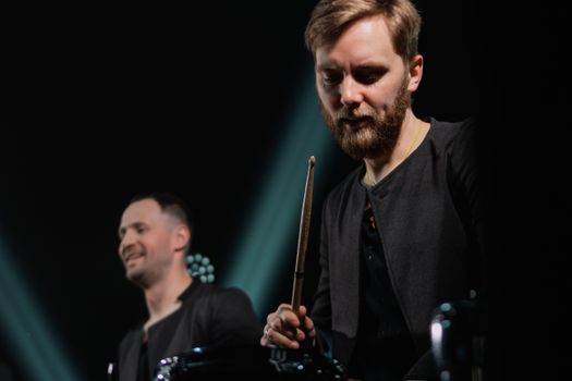 Dynamic shot of a drummer and bandmate on stage during an electrifying live concert.