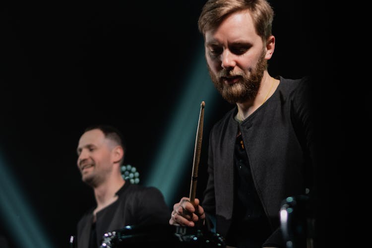 A Man Holding A Wooden Drumstick