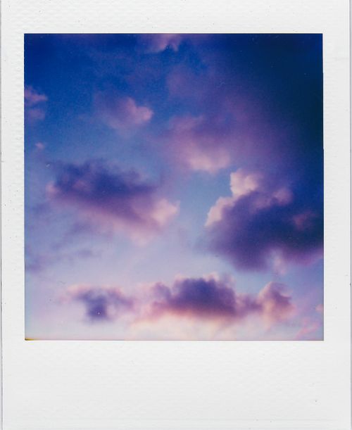 Free A dreamy sky with purple clouds at sunset captured in a classic polaroid frame, evoking nostalgic vibes. Stock Photo